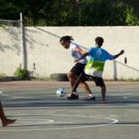 Players watch as young man tries to tackle ball from the opposing team.
Location: Behind Alfred Sangster Auditorium
Date: December 12,2025